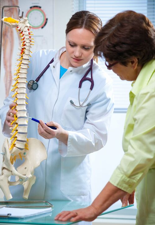 doktor bir maket üzerinde omurganın osteokondrozunu gösteriyor